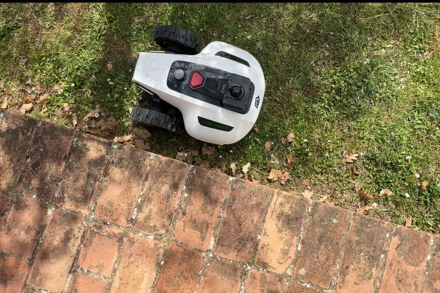 Mammotion YUKA mini 2 Mähroboter an einer Rasenkante mit sichtbarem ungemähtem Randstreifen